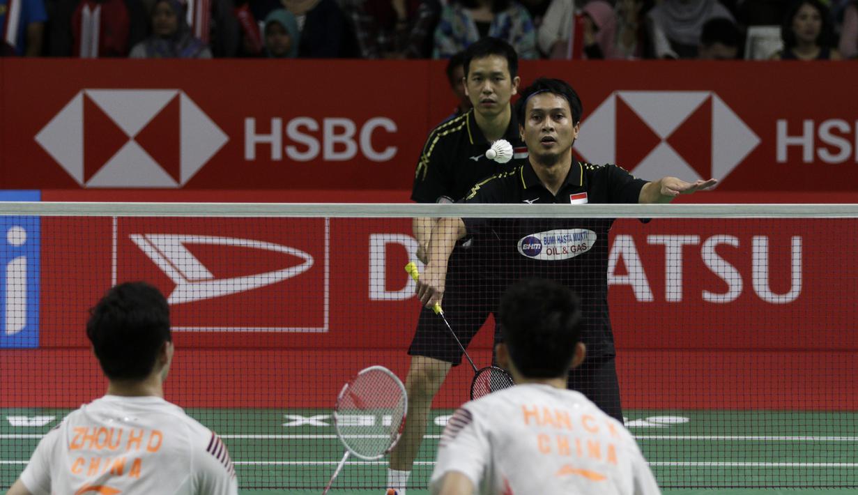 Ganda putra Indonesia, Mohammad Ahsan, melakukan servis saat melawan ganda China pada Indonesia Masters 2019 di Istora Senayan, Jakarta, Sabtu (26/1). Ahsan / Hendra ke final. (Bola.com/Yoppy Renato)