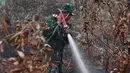 Prajurit TNI berusaha memadamkan kebakaran hutan dan lahan di Kabupaten Kampar, Provinsi Riau (12/9/2019). Kebakaran hutan yang terjadi menyebarkan kabut asap di Asia Tenggara. (AFP Photo/Adek Berry)