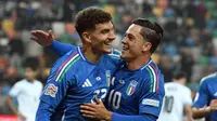 Pemain Timnas Italia, Giovanni Di Lorenzo dan Giacomo Raspadori, merayakan gol yang tercipta ke gawang Israel dalam laga UEFA Nations League 2024/2025 di Friuli Stadium, Selasa (15/10/2024) dini hari WIB. (Tiziana FABI / AFP)