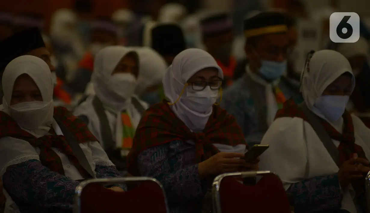 Jemaah calon haji kelompok terbang (kloter) 1 embarkasi haji Jakarta - Pondok Gede menunggu keberangkatan menuju Bandara Soekarno - Hatta di Asrama Haji Pondok Gede, Jakarta, Sabtu (4/6/2022) dini hari. Sebanyak 389 calon haji asal DKI Jakarta yang tergabung dalam kloter 1 embarkasi haji Jakarta - Pondok Gede diberangkatkan menuju tanah suci Arab Saudi melalui Bandara Internasional Soekarno - Hatta. (merdeka.com/Imam Buhori)