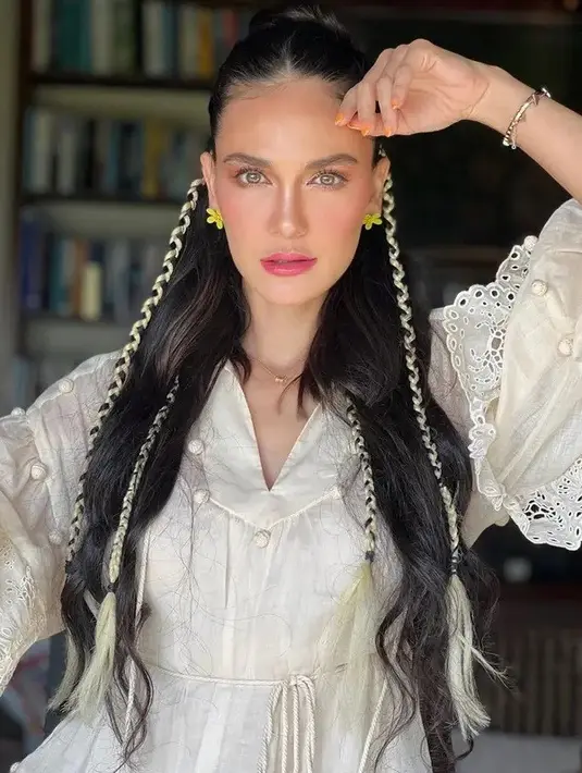 Penampilannya disempurnakan dengan gaya rambut yang ditata bergelombang dan beberapa bagian dikepang. Riasan wajah memesona merupakan hasil karya MUA Ryan Ogilvy. [Foto: Instagram/lunamaya]