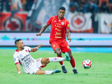 Pemain Persija Jakarta, Alan Cardoso, berusaha melewati pemain Bali United, Mirza Mustafic, dalam lanjutan BRI Super League 2025/2026 di Jakarta International Stadium (JIS), Minggu (14/9/2025) malam WIB. (Bola.com/M Iqbal Ichsan)