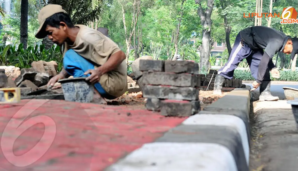 Perbaikan trotoar dan pengecatan kembali dilakukan oleh para pekerja terhadap trotoar yang terletak di dekat Jalan Sudirman. (Liputan6.com/Johan Tallo)