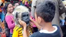 Sejumlah anak mencoba topeng yang dijajakan oleh para pedagang di Ragunan, Jakarta, Minggu (27/12/2015). Pedagang mengaku omset penjualan pada Libur Natal kali ini melonjak 3x lipat dari pada biasanya. (Liputan6.com/Helmi Afandi)