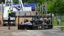 Sebuah mobil uji coba F1 kembali diangkat menuju kendaraan angkut di sirkuit Autodromo Enzo e Dino Ferrari, Kamis (18/5/2023), setelah banjir bandang melanda kawasan tersebut sehari sebelumnya. (AFP/Andreas Solaro)