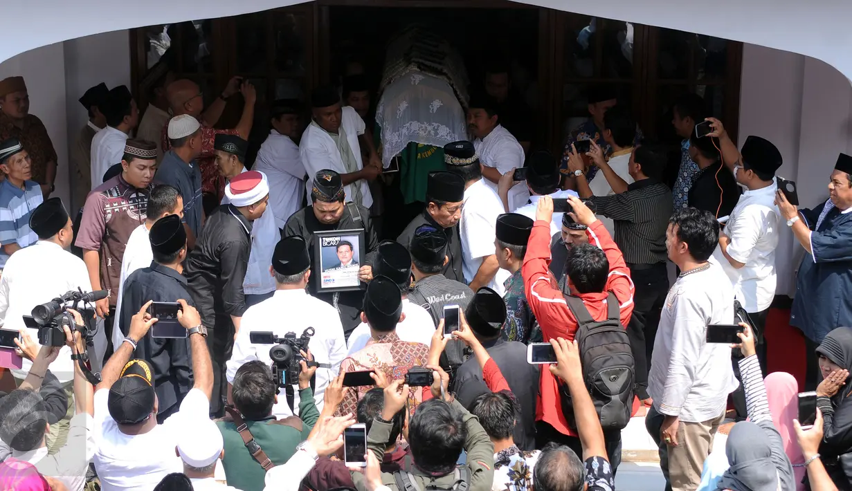 Sejumlah pelayat bersiap menggotong jenazah Ketua KPU Husni Kamil Manik usai disalatkan di Kompleks KPU, Jakarta, Jumat (8/7). Husni Kamil Manik wafat diusia 40 tahun pada Kamis malam (7/7). (Liputan6.com/Helmi Fithriansyah)