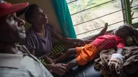 Sepasang suami istri menemani anak mereka yang sedang dirawat di klinik setempat di desa Ayam distrik Asmat, di provinsi Papua Barat (26/1). Jumlah tersebut terhitung sejak September 2017 hingga 24 Januari 2018. (AFP/Bay Ismoyo)