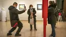 Seorang perempuan berpose untuk foto di galeri di Museum Seni Nasional China di Beijing, Rabu (1/2/2023). Pengunjung terus berduyun-duyun ke museum, situs bersejarah, dan tempat wisata di ibu kota China saat periode liburan Tahun Baru Imlek berakhir. (AP Photo/Mark Schiefelbein)