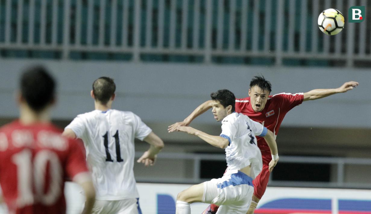 Pemain Korea Utara duel udara dengan pemain Uzbekistan pada laga PSSI Anniversary Cup 2018 di Stadion Pakansari, (27/4/2018). Korea Utara bermain imbang 2-2 dengan Uzbekistan. (Bola.com/M Iqbal Ichsan)