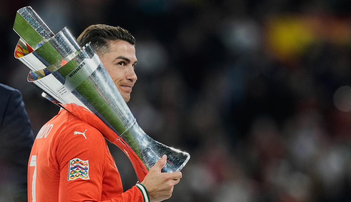 Pemain Portugal, Cristiano Ronaldo, mengangkat trofi saat menjuarai UEFA Nations League 2025 setelah menaklukkan Timnas Spanyol lewat drama adu penalti di Allianz Stadium, Senin (09/06/2025) dini hari WIB. (AP Photo/Martin Meissner)