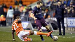 Bek Arsenal, Stephan Lichtsteiner, berebut bola dengan pemain Blackpool, Armand Gnanduillet, pada laga Piala FA di Stadion Bloomfield Road, Sabtu (5/1). Arsenal menang 3-0 atas Blackpool. (AP/Anthony Devlin)