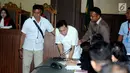 Tersangka korupsi e-KTP, Setya Novanto berbincang dengan kuasa hukum saat memasuki ruang sidang Pengadilan Tipikor, Jakarta, Rabu (13/12). Saat sidang Ketua Majelis Hakim Yanto menanyakan identitas dan kondisi kesehatan. (Liputan6.com/Helmi Fithriansyah)
