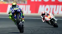 Pebalap Movistar Yamaha, Valentino Rossi, mengangkat ban depan motornya saat kualifikasi MotoGP Valencia di Sirkuit Ricardo Tormo, Valencia, Spanyol, (7/11/2015) (AFP Photo/Jose Jordan)