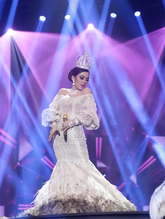 Gaun putih bertabur perhiasan mewah dan mengenakan mahkota indah membuat penyanyi cetar membahana ini terlihat makin percaya diri. (Andy Masela/Bintang.com)