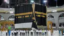 Kiswah baru, atau kain hitam dipasangkan di situs paling suci Islam, Ka'bah di Mekah (29/7/2020). Kiswah adalah kain hitam dengan bordir emas yang menutupi Ka'bah di Makkah, Saudi Arabia diganti setiap tahun selama ibadah haji menjelang perayaan Idul Adha. (Saudi Media Ministry via AP)