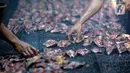 Pekerja menyusun ikan lele yang diasapin (panggang) di Kelurahan Pengasinan, Bogor, Jawa Barat, Jumat (11/09/2020). Permintaan ikan lele asap meningkat dalam satu hari bisa memproduksi 4 sampai 5 kuintal yang akan di kirim ke Jabodetabek hingga di ekspor ke Nigeria. (merdeka.com/Dwi Narwoko)
