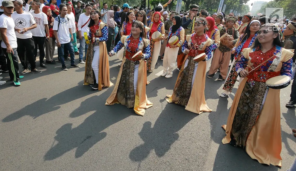 Warga menyambut antusias pawai obor Asian Para Games 2018 ketika melintas di kawasan Jakarta, Minggu (30/9). Nantinya api obor ini akan diarak di 17 titik lokasi di Ibu Kota. (Liputan6.com/Herman Zakahria)