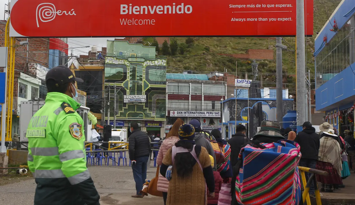 Seorang polisi memeriksa lalu lintas pejalan kaki di perbatasan Peru dengan Bolivia di desa Desaguadero, Peru, pada 18 Februari 2022. Setelah ditutup selama hampir dua tahun karena pandemi Covid-19, Peru mengizinkan pembukaan kembali perbatasan dengan Bolivia dan Ekuador. (Carlos MAMANI/AFP)