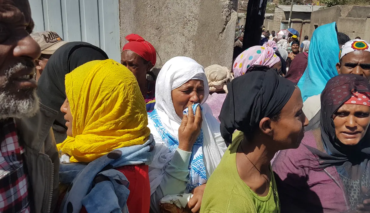 Reaksi warga saat petugas menemukan jasad korban longsoran sampah di tempat pembuangan akhir (TPA) luar ibu kota Ethiopia, Addis Ababa, Minggu (12/3). Sedikitnya 48 orang tewas tertimbun longsoran sampah yang jumlahnya berton-ton. (AP Photo/Elias Meseret)