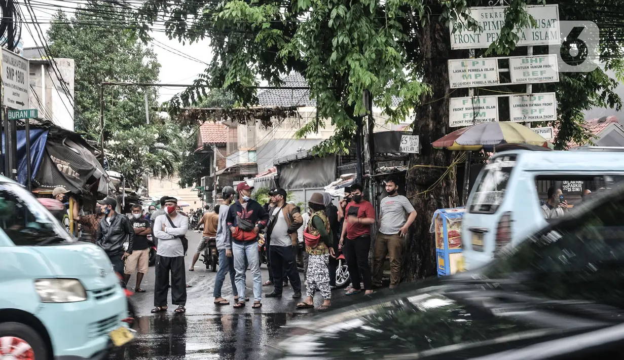 Warga saat menyaksikan petugas kepolisian menyemprotkan cairan disinfektan menggunakan kendaraan meriam air di Kawasan Petamburan, Jakarta, Minggu (22/11/2020). (merdeka.com/Iqbal S. Nugroho)