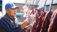 Kepala Dinas Pertanian dan Pangan Banyuwangi Arief Setiawan memeriksa daging sapi di Pasar Induk Banyuwangi (Istimewa)