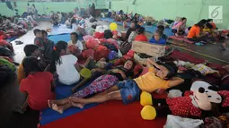 Warga beristirahat di lokasi pengungsian di GOR Suweca, Klungkung, Bali, Selasa (26/9). Ribuan pengungsi terus berdatangan menyusul peningkatan frekuensi gempa yang mulai dirasakan warga di kawasan Gunung Agung. (Liputan6.com/Gempur M Surya)