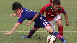 Pemain Timnas Indonesia U16, Egi Maulana, berusaha melewati pemain Jepang U16 saat ujicoba di Lapangan Padepokan Voli Indonesia di Sentul, Bogor, Jawa Barat. Selasa (15/4).