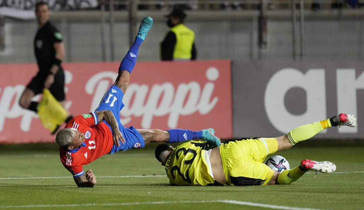 Pemain Chile Eduardo Vargas (kiri) berebut bola dengan penjaga gawang Argentina Emiliano Martinez (kanan) pada pertandingan sepak bola Kualifikasi Piala Dunia 2022 di Stadion Zorros del Desierto, Calama, Chile, 27 Januari 2022. Argentina menang 2-1. (Esteban Felix/POOL/AFP)