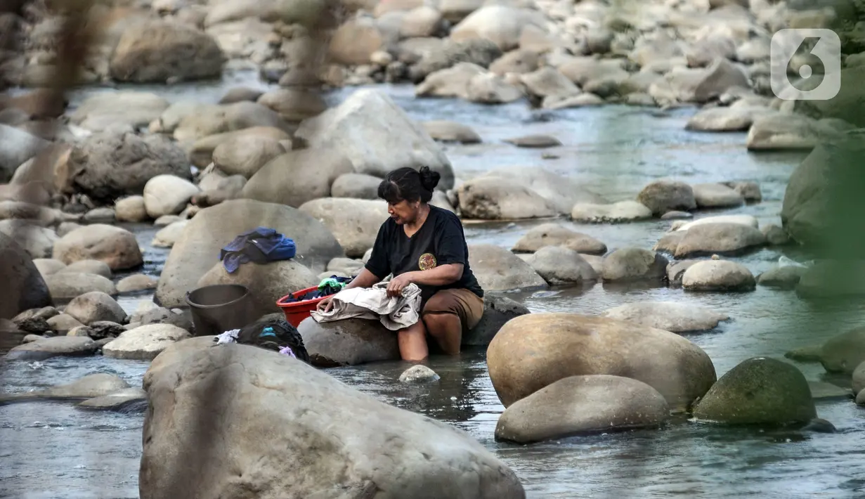 Warga mencuci pakaian di Sungai Cipamingkis, Desa Jagaita, Jonggol, Kabupaten Bogor, Jawa Barat, Kamis (29/7/2021). Warga setempat terpaksa memanfaatkan Sungai Cipamingkis untuk mandi dan mencuci pakaian meski aliran mulai mengering. (merdeka.com/Iqbal S. Nugroho)
