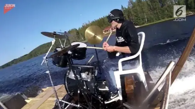 Seorang pria mampu unjuk gigi dengan memainkan drum pada perahu yang melaju di atas air.