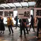 Demonstran menunjukkan pesan tuntutan mereka saat ribuan pegawai negeri sipil (PNS) mengikuti unjuk rasa menolak RUU Ekstradisi di Hong Kong, Jumat (2/8/2019). Banyak PNS yang memakai topeng hitam untuk menyembunyikan identitas mereka. (LAUREL CHOR/AFP)