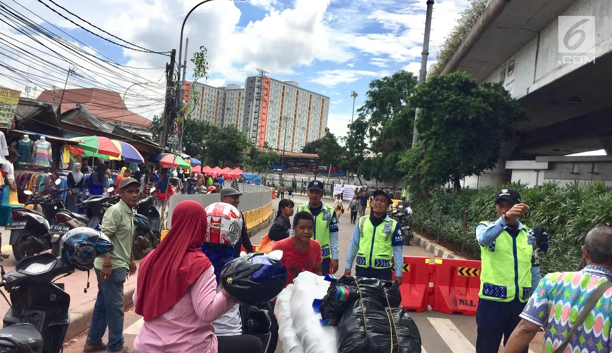 Petugas mengatur lalu lintas di Jalan Jati Baru Raya, Jakarta, Jumat (22/12). Terkait penataan PKL, Pemprov DKI Jakarta mulai menutup sepanjang jalan di depan Stasiun Tanah Abang pukul 08.00-18.00 WIB. (Liputan6.com/Immanuel Antonius)