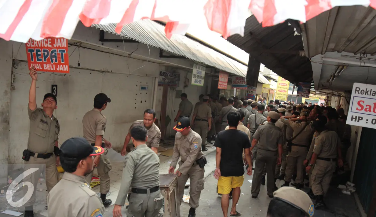 Petugas Satpol PP membawa barang-barang yang berada di kios Kavling 36 Pasar Benhil, Jakarta, (29/8/2015). Pembongkaran dilakukan berdasarkan putusan PTUN Jakarta yang memenangkan PD Pasar Jaya. (Liputan6.com/Gempur M Surya)