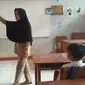 Nining (44), guru honorer yang sudah 15 tahun mengabdi di SDN Karyabuana 3, Kecamatan Cigeulis, Kabupaten Pandeglang, Banten, terpaksa membuat 'rumah' satu atap dengan toilet sekolah dalam dua tahun terakhir. (Liputan6.com/Yandhi Deslatama)