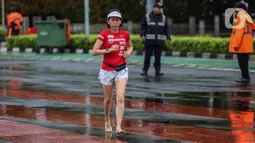 Seorang perempuan berolahraga di tengah rintik hujan pada Car Free Day atau hari bebas kendaraan di kawasan Bundaran Hotel Indonesia (HI), Jakarta, Minggu (12/2/2023). Hujan yang mengguyur Ibu Kota sejak malam sampai pagi ini tak menyurutkan semangat warga untuk tetap berolahraga di area CFD. (Liputan6.com/Johan Tallo)