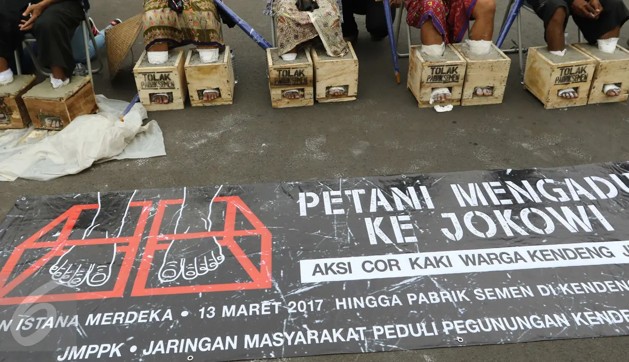 Sebuah spanduk besar yang didampang saat sejumlah Petani Kendeng, Pati menggelar aksinya di depan Istana Negara, Jakarta, Selasa (14 /3). (Liputan6.com/Helmi Afandi)