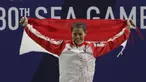 Lifter Aisyah Windy mengibarkan bendera saat naik podium usai mendapatkan medali emas SEA Games 2019 cabang angkat besi nomor 49 kg di Stadion Rizal Memorial, Manila, Minggu (1/12). Dirinya meraih emas dengan total angkatan 104 kg. (Bola.com/M Iqbal Ichsa