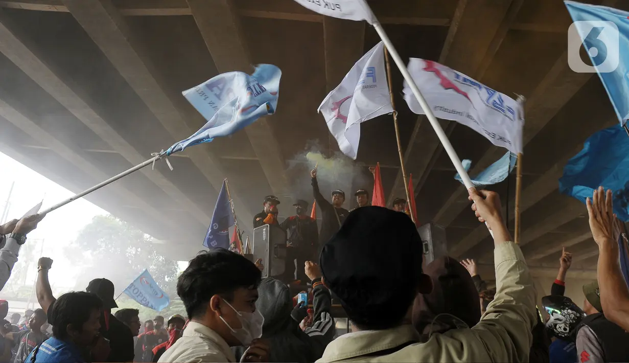 Massa buruh berorasi sambil mengibarkan berndera saat demo menuntut kenaikan upah minimum kabupaten/kota (UMK) Kabupaten Bekasi. (merdeka.com/Imam Buhori)