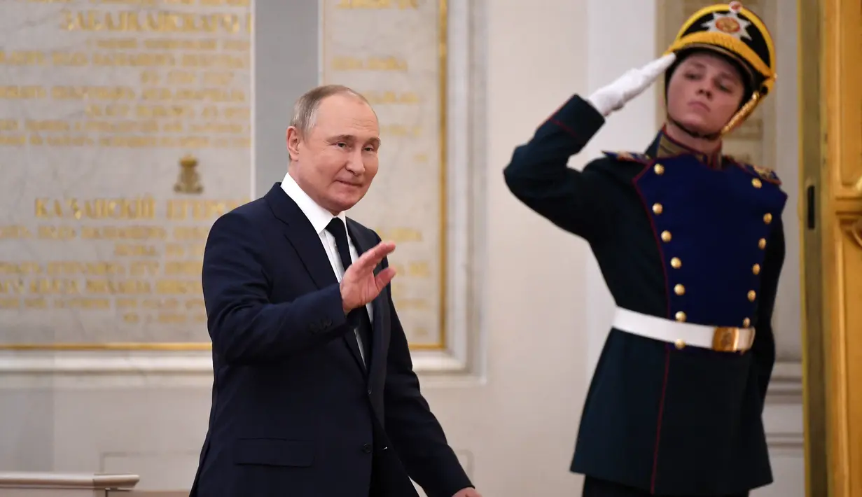 <p>Presiden Rusia Vladimir Putin melambaikan tangan saat menjamu atlet Rusia peraih medali Olimpiade Musim Dingin Beijing 2022 dan anggota tim Paralimpiade negara itu di Kremlin di Moskow (26/4/2022). (AFP/NATALIA KOLESNIKOVA)</p>