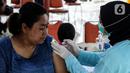 Petugas menyuntikkan vaksin COVID-19 dosis ketiga (booster) pada seorang perempuan di RPTRA Rusun Benhil, Jakarta, Rabu (6/7/2022). Selain itu, vaksin booster juga jadi syarat bagi masyarakat yang ingin melakukan perjalanan menggunakan transportasi umum. (Liputan6.com/Johan Tallo)