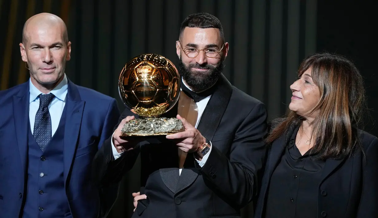 Pemain Real Madrid, Karim Benzema (tengah) bersama Zinedine Zidane (kiri) saat penganugerahan trofi Ballon d'Or 2022 di Theater du Chatelet, Paris, Prancis, Senin (17/10/2022). Keberhasilan Karim Benzema meraih trofi Ballon d'Or 2022 membuat striker Real Madrid itu mengikuti jejak dua pemain Los Blancos lainnya, Zinedine Zidane dan Ronaldo. (AP Photo/Francois Mori)