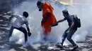 Para pengunjuk rasa bereaksi setelah polisi menembakkan gas air mata untuk membubarkan mereka di Kolombo, Sri Lanka, 9 Juli 2022. Perdana Menteri Sri Lanka Ranil Wickremesinghe meminta pembicara untuk memanggil parlemen, kata pernyataan dari kantor perdana menteri. (AP Photo/Amitha Thennakoon)