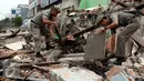 Petugas Satpol PP merapihkan puing-puing bangunan usai dihancurkan alat berat, Jakarta, Kamis (8/10/2015). Tiga bangunan permanen di Jalan Fatmawati, Jaksel dibongkar terkait proyek MRT. (Liputan6.com/Yoppy Renato)
