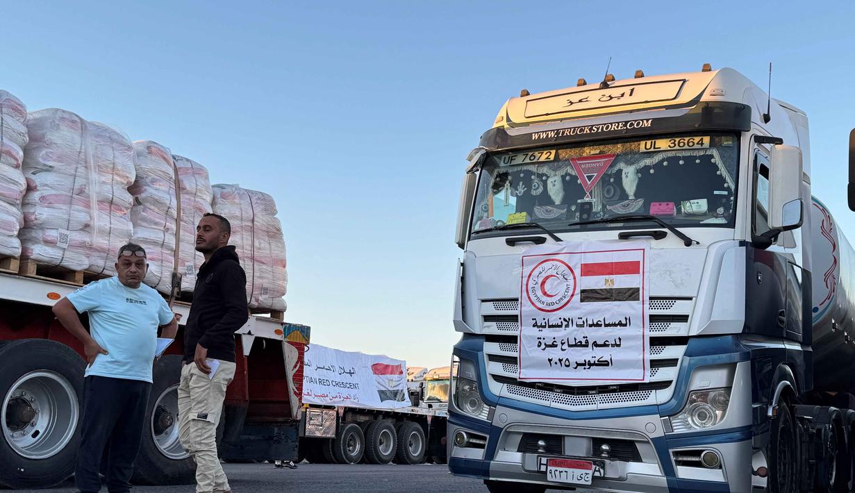 Truk-truk yang memuat bantuan kemanusiaan di sisi Mesir dari perlintasan Rafah menunggu untuk menyeberang ke Jalur Gaza pada 15 Oktober 2025. (Foto oleh AFP)