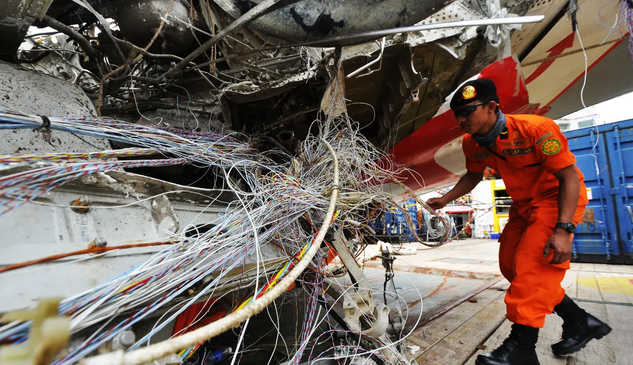 Petugas dari Basarnas memeriksa bangkai badan pesawat Airasia QZ8501 di Pelabuhan Tanjung Priok, Jakarta, Senin (2/3/2015). (Liputan6.com/Faizal Fanani)