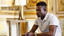 Imigran asal Mali, Mamoudou Gassama saat berbincang dengan Presiden Prancis Emmanuel Macron di Istana Elysee, Paris, Senin (29/5). Selain menawari kewarganegaraan, Macron meminta Gassama bekerja di pemadam kebakaran. (AP Photo/Thibault Camus, Pool)