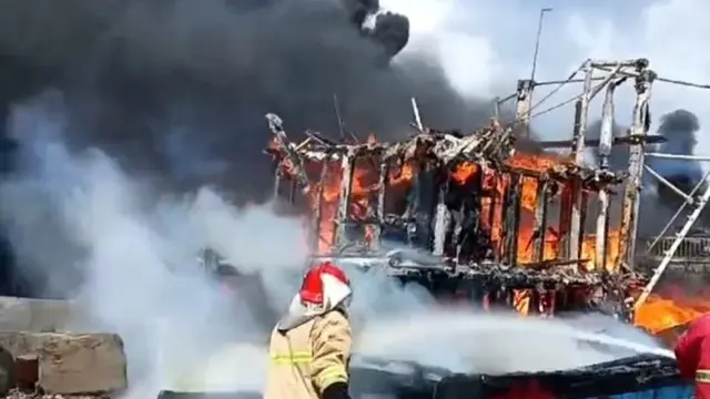 Petugas Pemadam kebakaran berjibaku memadamkan kapal ikan yang terbakar diu Pelabuhan Massami Banyuwangi (Istimewa)