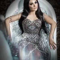 KD mengenakan gaun berwarna abu-abu yang dipenuhi payet hampir di  seluruh bagian. Di bagian bawah gaun tersebut dipadukan bahan chiffon yang transparan dan masih dipenuhi payet. (Instagram/krisdayantilemos)