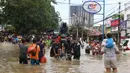 Pengendara sepeda motor melintasi banjir dengan menaiki ojek gerobak di Ciledug, Tangerang, Banten, Kamis (2/1/2020). Jasa ojek gerobak menjadi alternatif bagi warga untuk melintasi banjir. (Liputan6.com/Angga Yuniar)