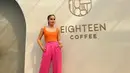 Tampil bergaya ala cewek kue untuk daily outfit, kombinasi dua warna cerah yang terdiri dari tank top berwarna oranye dan high waist pants berwarna magenta juga tak kalah menarik. (Instagram/claurakiehl).